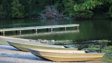 Small aluminum boats docked by the water, a common starting point before carpeting a jon boat for improved comfort and traction.