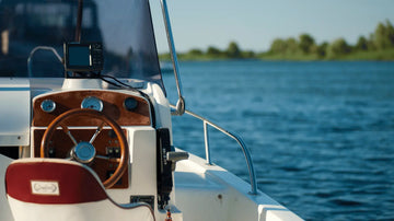 Boat deck with steering wheel on open water, illustrating common mistakes to avoid when installing boat carpet for a professional finish.