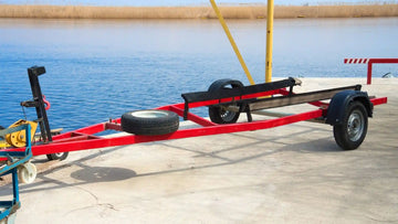 Empty boat trailer at a launch ramp with exposed bunks, illustrating when to replace trailer bunk boards for safe boat loading and transport